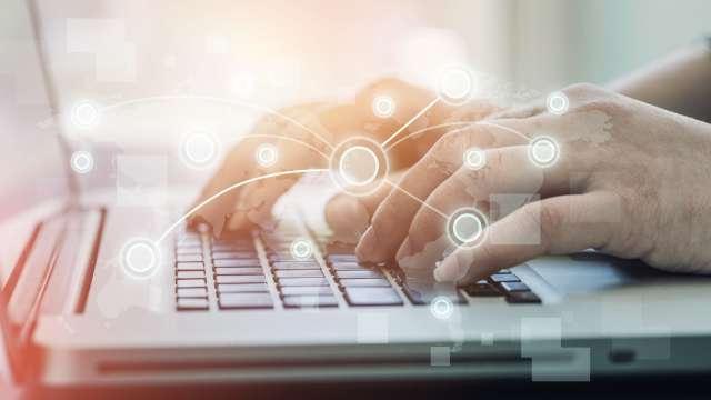 Hands typing at a laptop