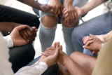 Young adults holding hands in a circle